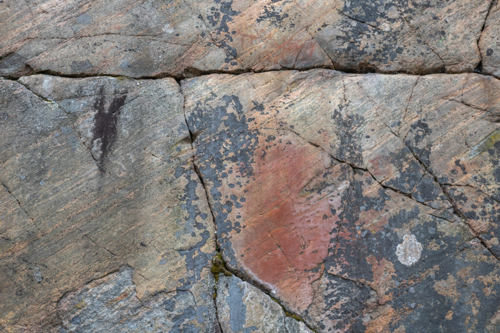 Kuvassa Syrjäsalmen kalliomaalaukset punaisella värillä kallioseinämässä.
